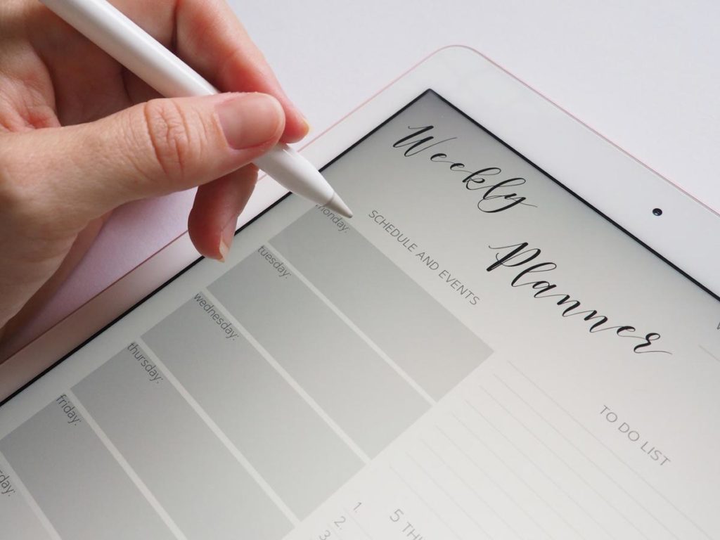Woman creating her weekly planner on an iPad