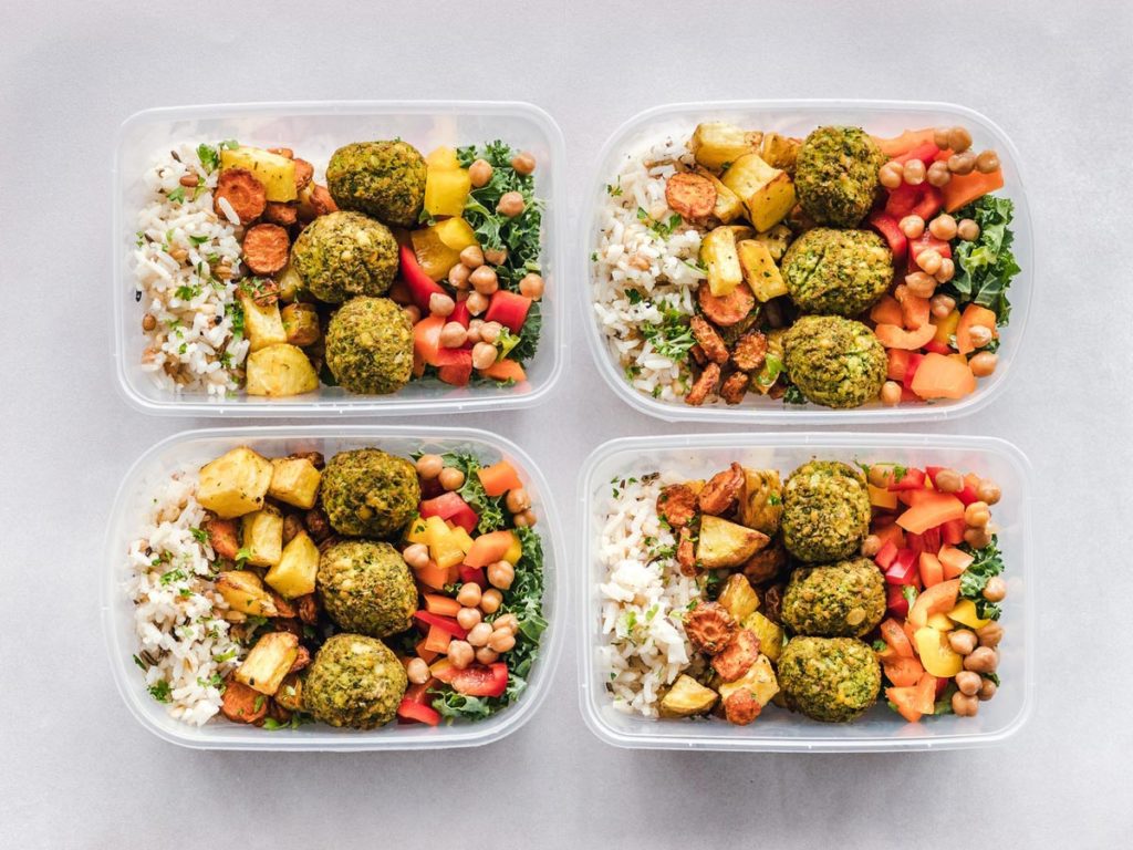 Four meal prep containers filled with healthy food