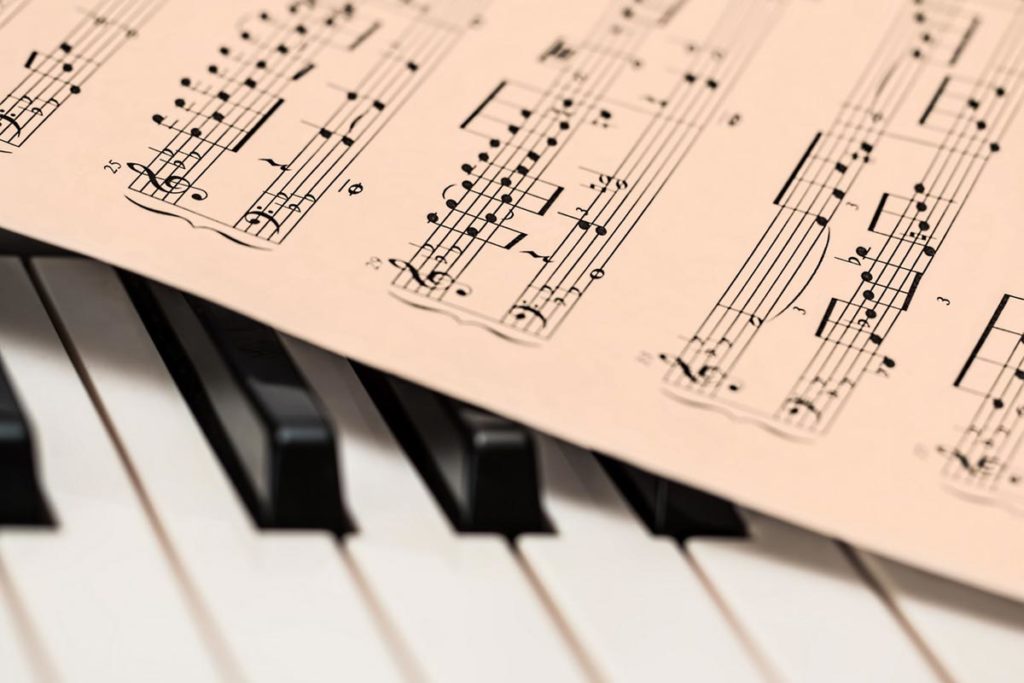 Piano keys with sheet of music on top
