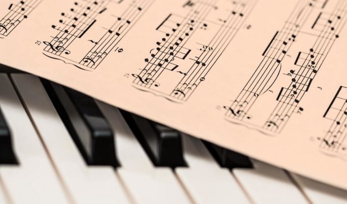 Piano keys with sheet of music on top