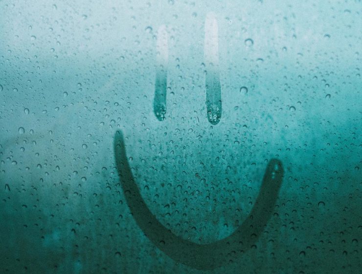 smiley face drawn on a rainy window