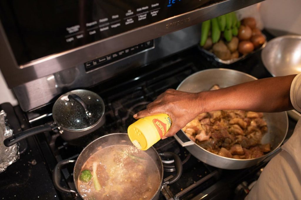 Woman in kitchen cooking caribbean food