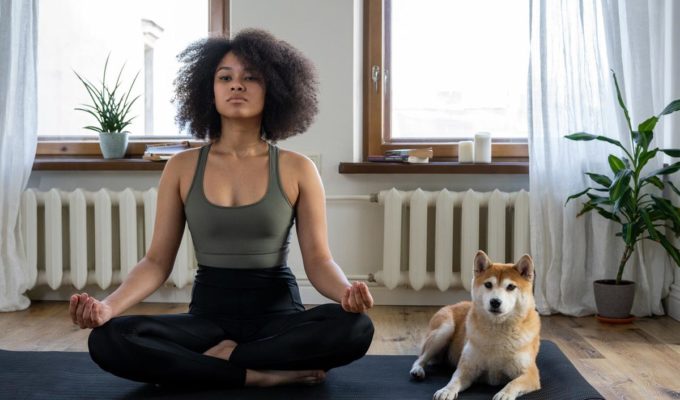 Woman sitting in yoga post with dog