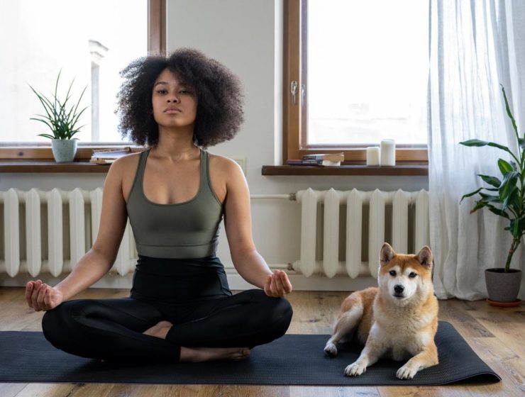 Woman sitting in yoga post with dog